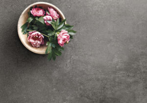 gresie si faianta de calitate | Old Wooden Bowl Filled With Peonies Alongside A Woman In Sandals | Gresie Premium | Importator gresie faianta parchet de calitate din Italia