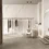 Luxurious boutique interior with marble walls, a clothing rack with neutral garments, and a cushioned chair.