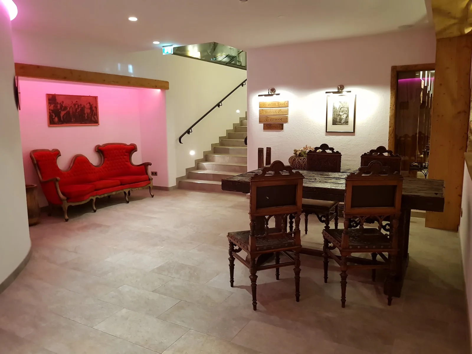 Hol de hotel cu pardoseală din plăci mari aspect piatră, scară și mobilier clasic