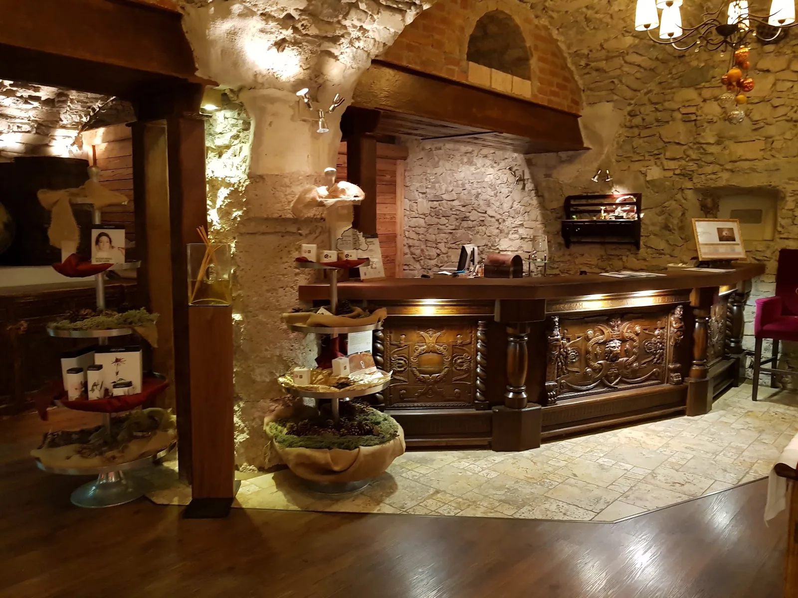 Recepție de hotel cu pereți din piatră și trecere de la pardoseala aspect piatră la cea aspect lemn