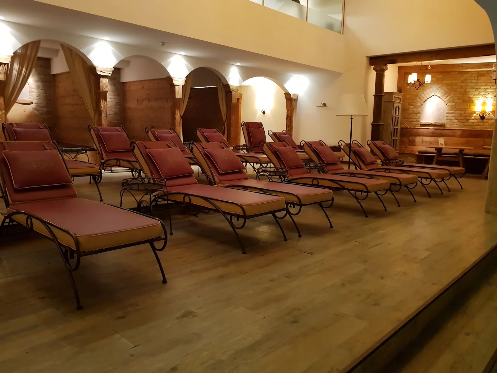 Zonă de relaxare într-un spa de hotel, cu pardoseală aspect lemn și șezlonguri