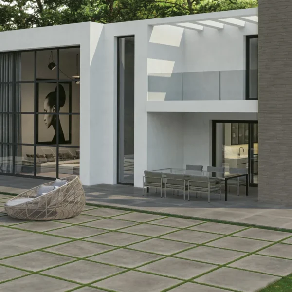 Gresie exterior 20 mm LeGarage Silver Cerdomus pe terasa unei vile moderne, lângă piscină, montaj pe iarbă cu rosturi verzi